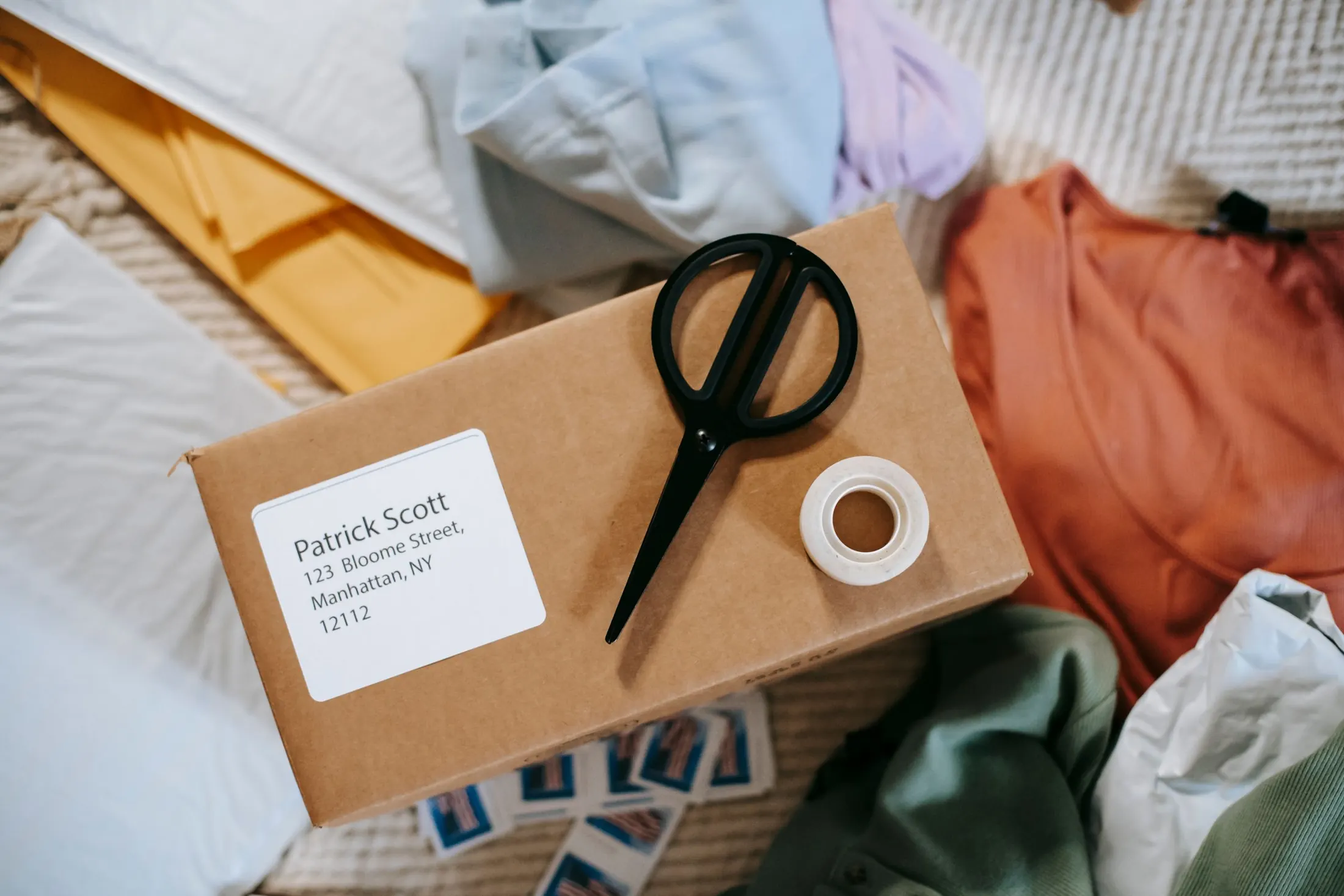 A parcel with an address label, tape and scissors